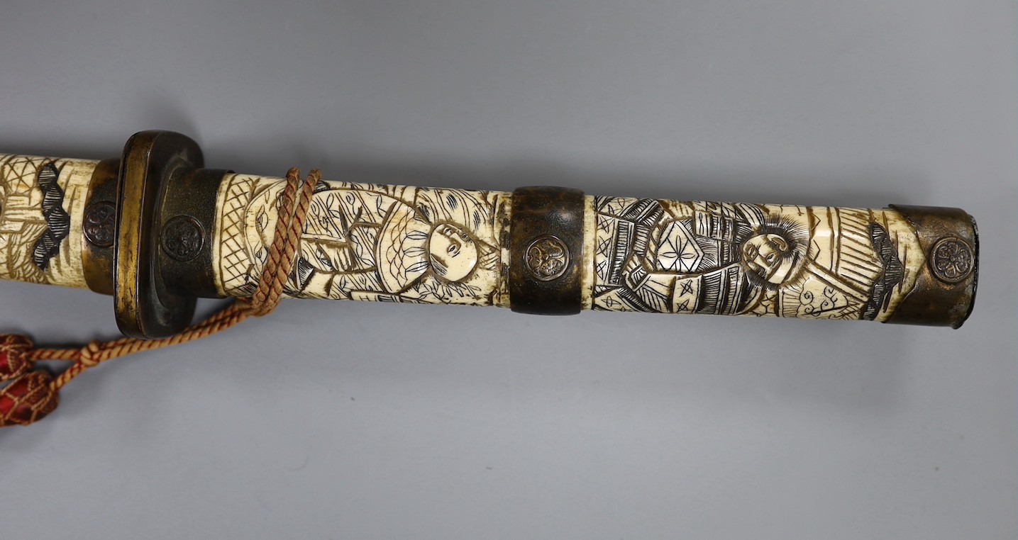 A late 19th century Japanese wakizashi sword, the blade 47.5cm, with sectional stag's horn scabbard and hilt carved with warriors and other figures, gilt metal mounted